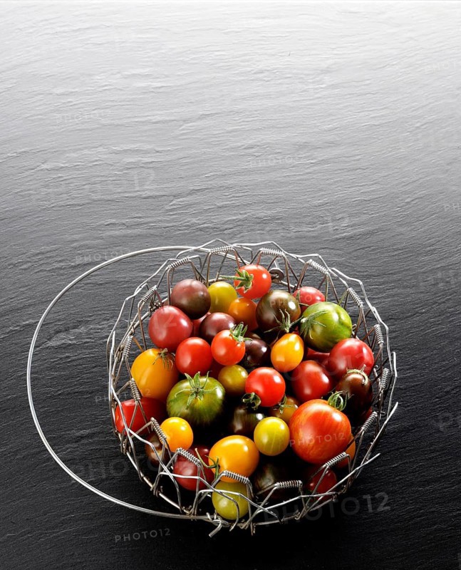 Various wild tomatoes in a wire basket