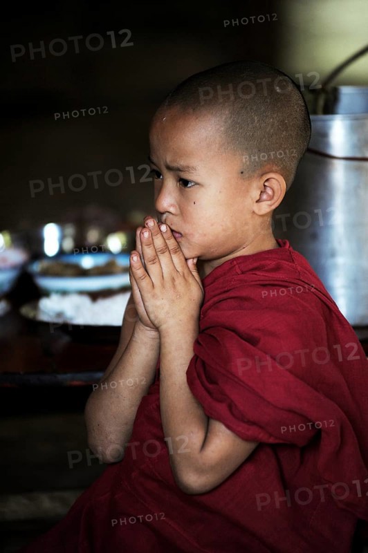 Buddhist novice praying in a monastery