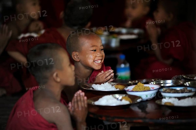 Buddhist novices praying before eating their meal in a monastery