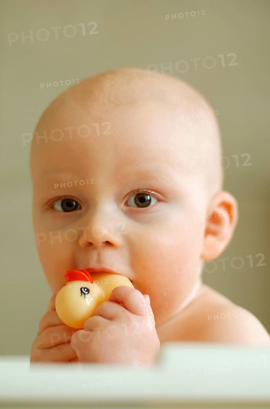 Baby with a rubber duck in his mouth