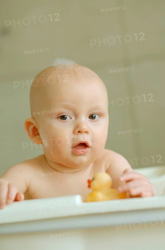Baby in a bath with foam on his head