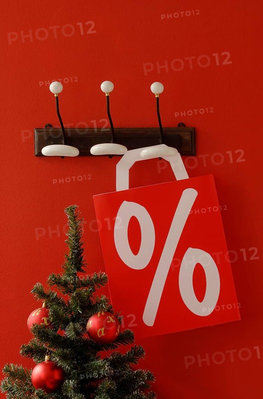 Shopping bag with per cent sign hanging on nostalgic coat hooks