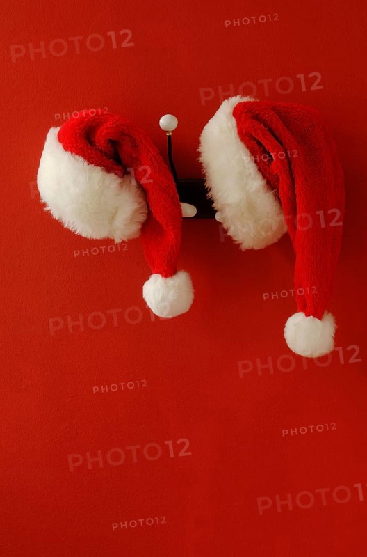 Two Santa hats on hanging on nostalgic coat hooks
