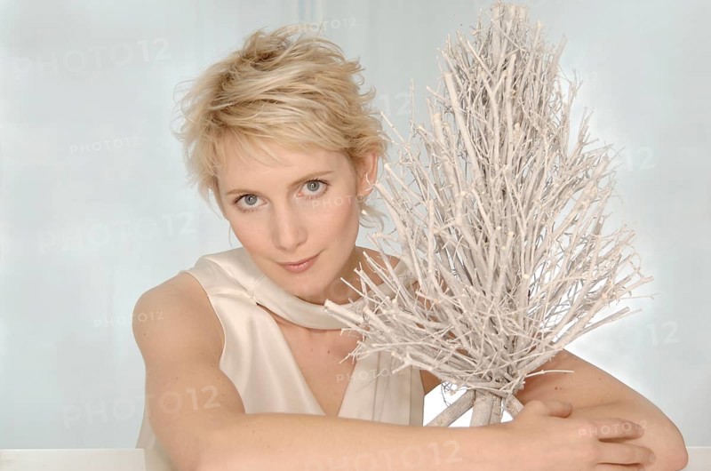 Blonde woman hugging a white brushwood tree