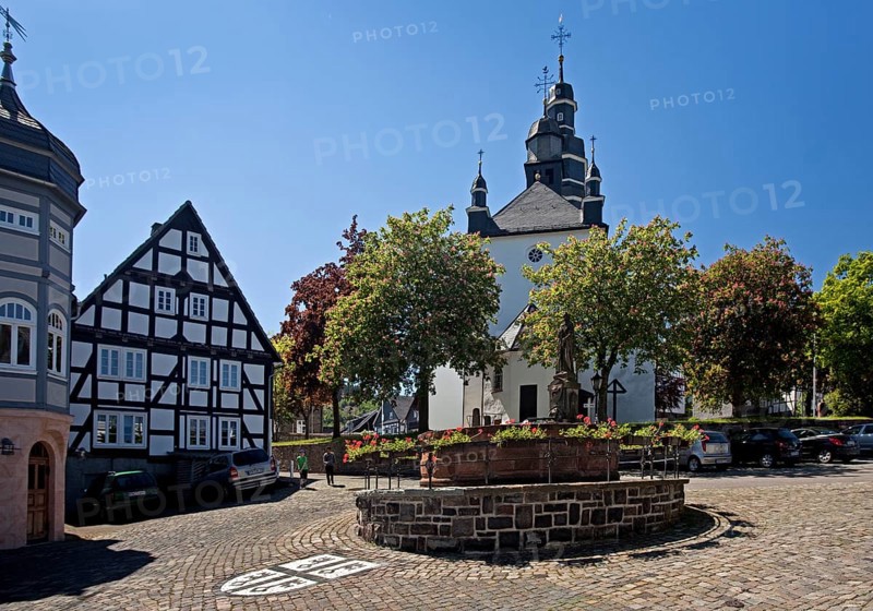 St. Peter's Fountain with the town coat of arms and the Church of St. Heribert in Hallenberg