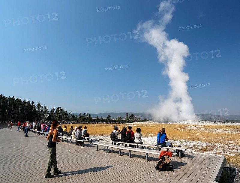 Tourists watching the eruption of the Old Faithful geyser