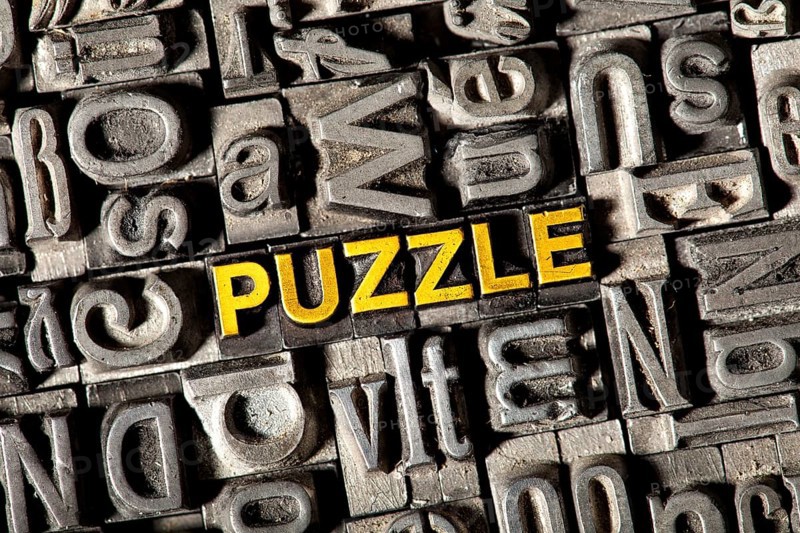 Old lead letters forming the word 'PUZZLE'