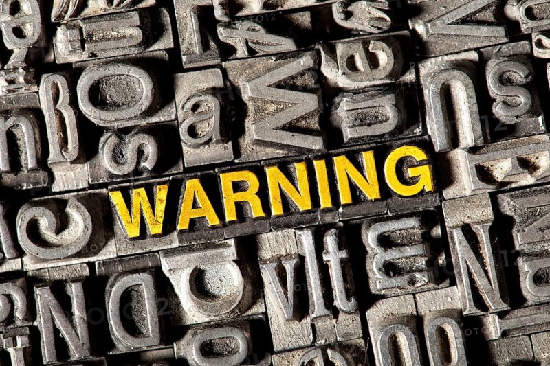 Old lead letters forming the word Warning