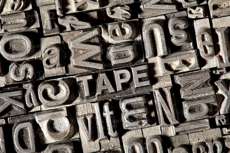 Old lead letters forming the word TAPE