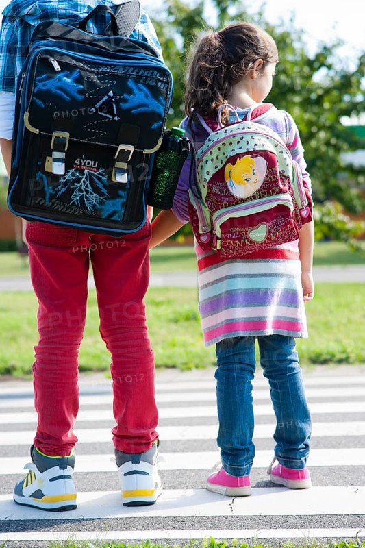 Children carrying school bags on the way to school