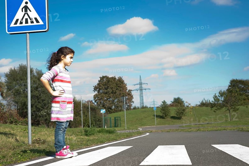 Girl waiting at a zebra crossing