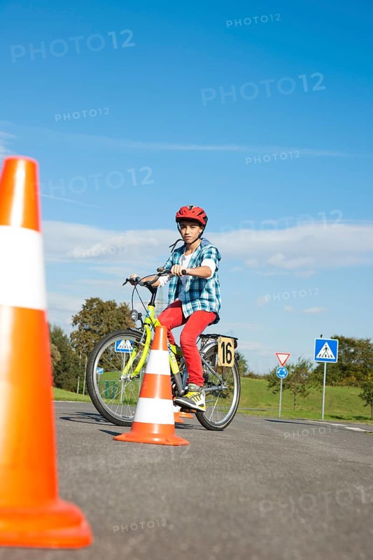 Child practicing to ride slalom on a bicycle at a traffic awareness course