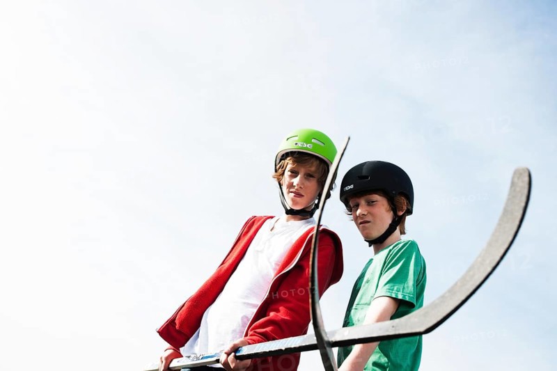 Two cool boys playing roller hockey with hockey sticks