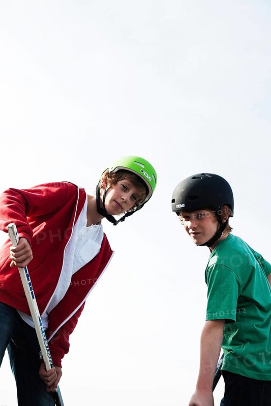 Two cool boys playing roller hockey with hockey sticks
