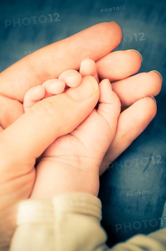 Hand of mother holding hand of baby