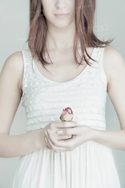 Young woman holding a rose in her hands