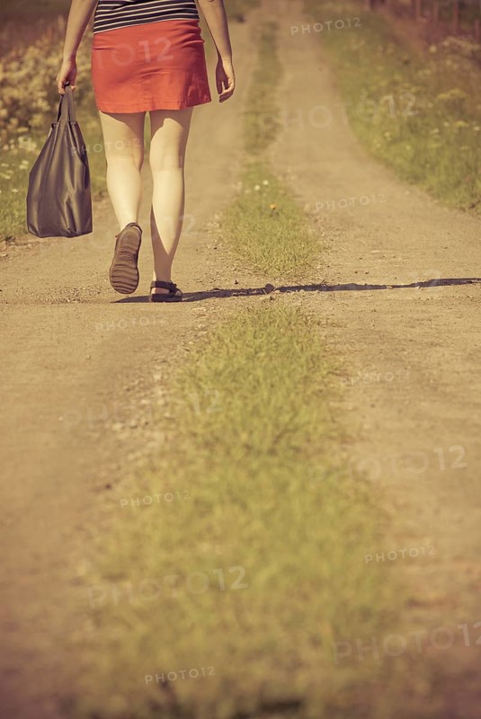 Woman walking on a dirt road