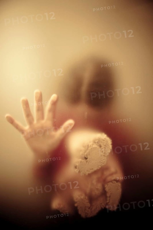 Woman looking down and holding a teddy bear