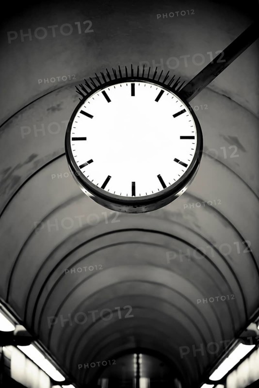 Empty clockface in a deserted walkway tunnel
