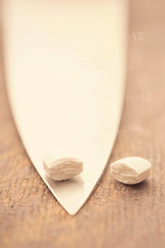 Medical capsule divided into two halves by large knife