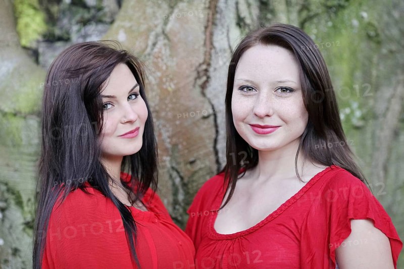 Two sisters in front of an old tree