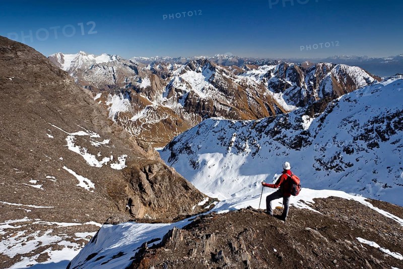 Mountain climber on the summit ridge while descending from Wilde Kreuzspitze Mountain in the Pfunderer Mountains