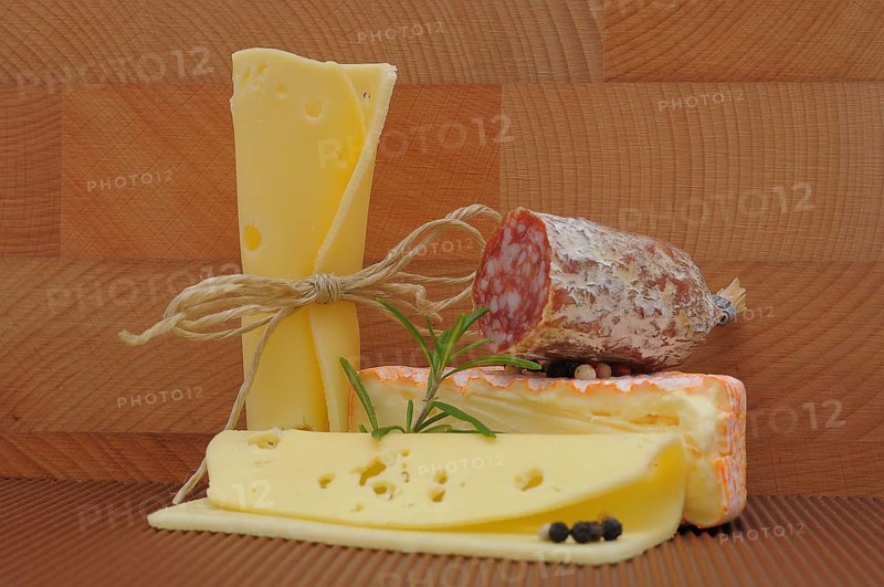 Various types of cheeses and a piece of salami