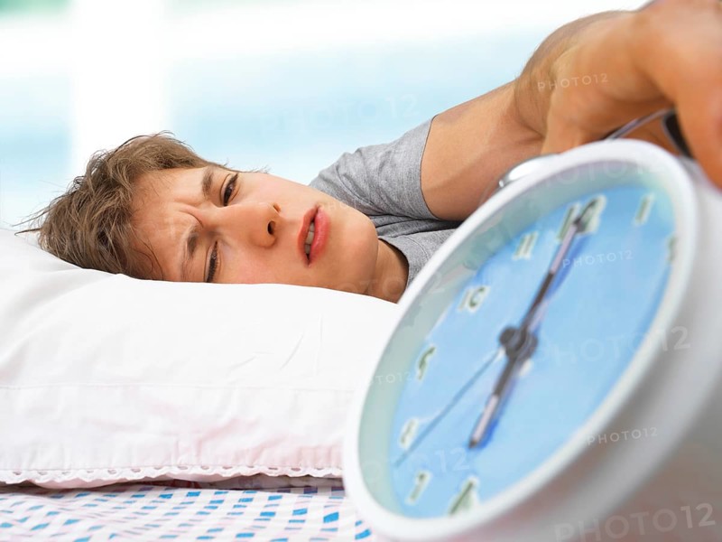 Young man with an alarm clock