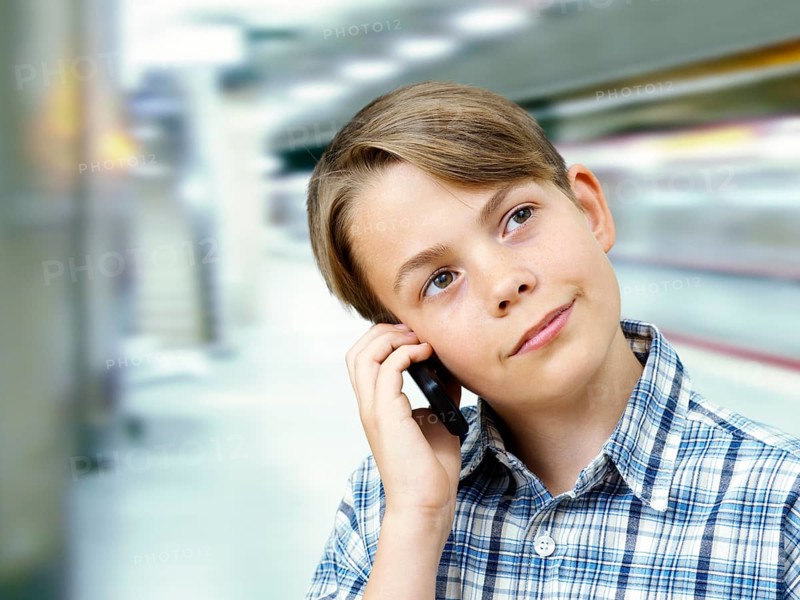 Teenager using a mobile phone in an underground railway station