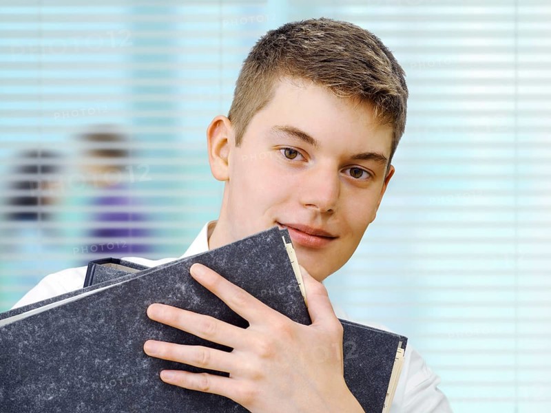 Apprentice or trainee holding files in an office