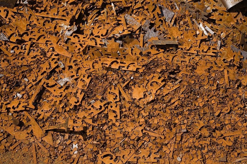 Assorted rusted metal brackets at a scrap metal recycling junkyard
