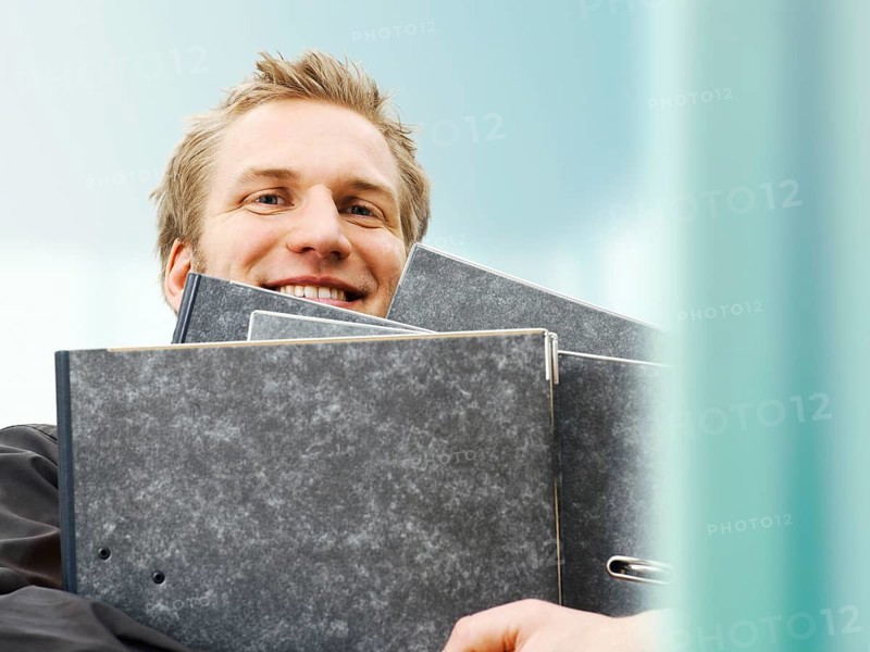 Businessman carrying ring binders