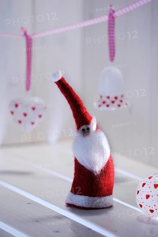 Christmas ambience with a felt Santa Claus and Christmas tree ornaments made of glass