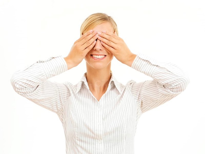 Young woman holding her hands over her eyes
