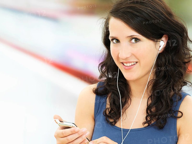 Young woman listening to music at a subway station
