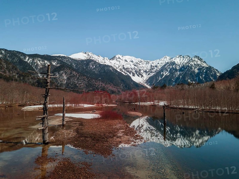 Snow-covered Japanese Alps reflected in Lake Taisho Pond