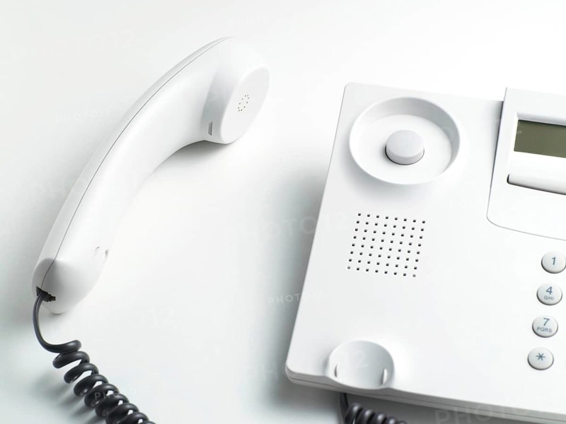 Handset laying beside a telephone
