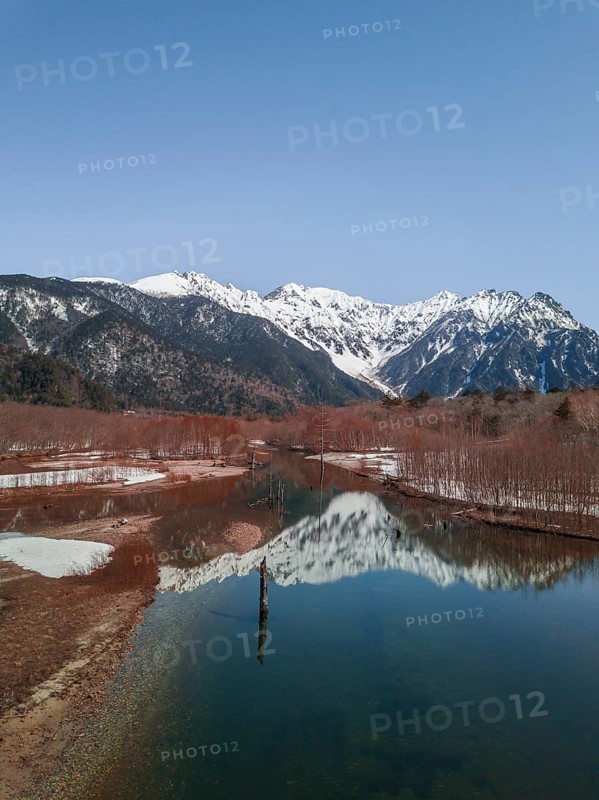 Snow-covered Japanese Alps reflected in Lake Taisho Pond
