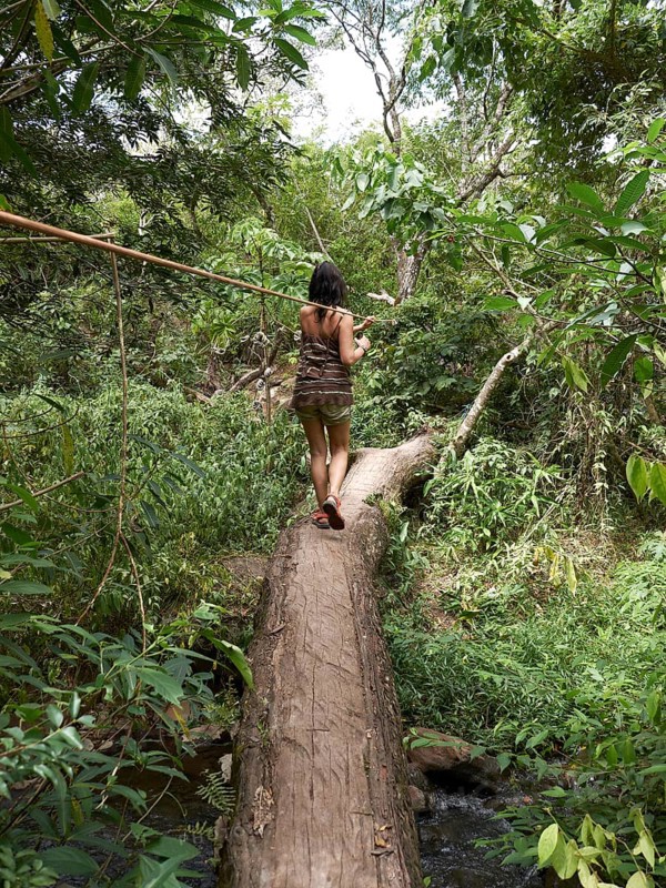 Woman balancing on a tree trunk