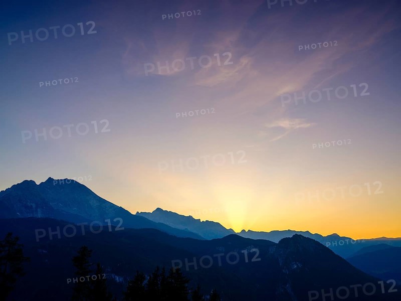 Mountain silhouettes reflected in an artificial mountain lake at sunset