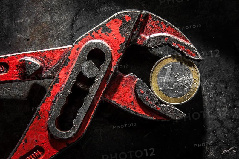 A Greek euro coin under pressure in a monkey wrench