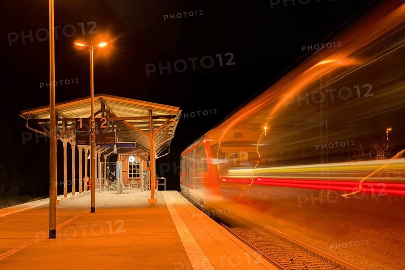 Railway station at night with moving train