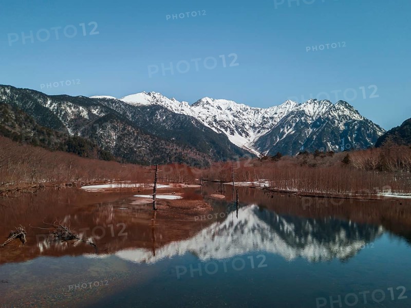 Snow-covered Japanese Alps reflected in Lake Taisho Pond