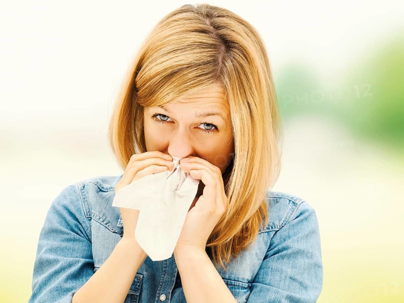 Young woman blowing her nose