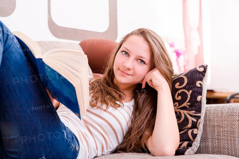 Girl reading a book on the sofa