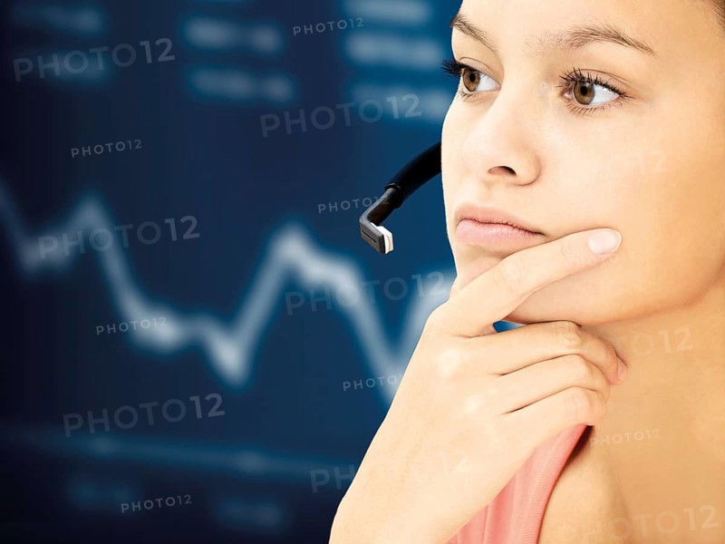 Businesswoman wearing a headset in front of a stock market curve