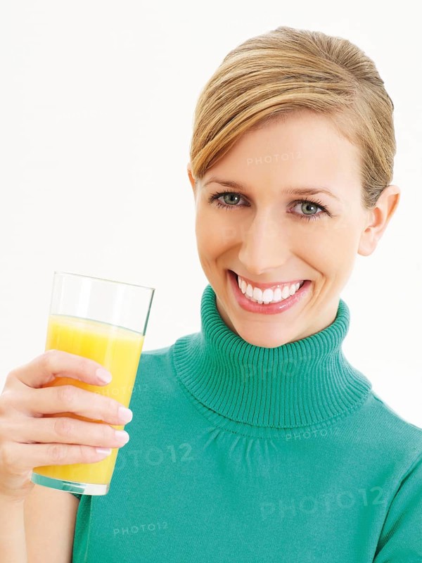 Young woman holding a glass of orange juice