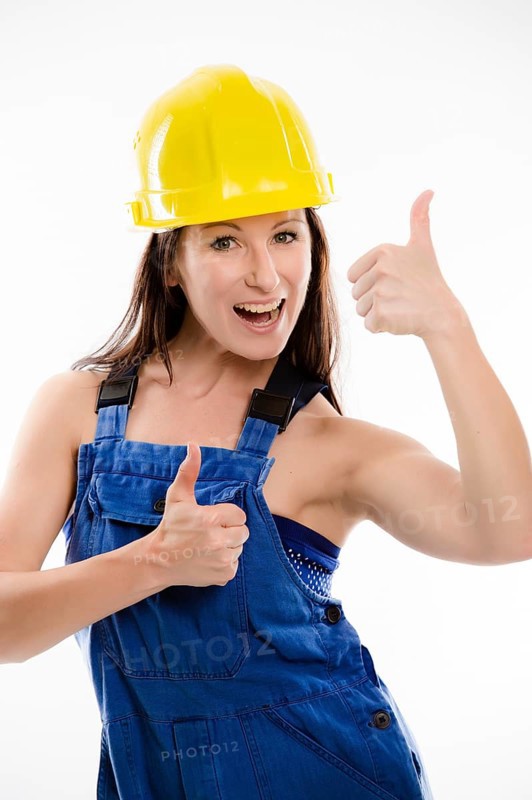 Woman wearing blue overalls and a hardhat