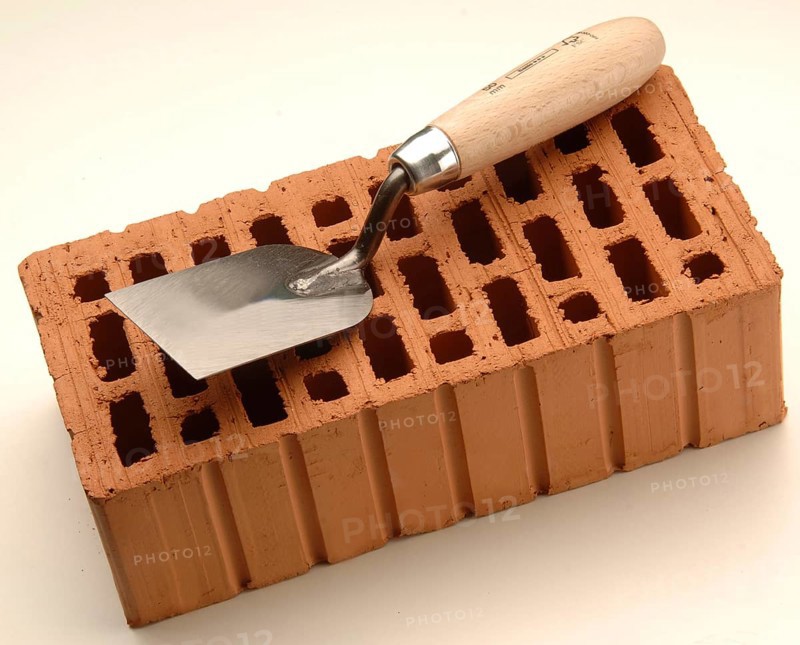Smoothing trowel on a red brick