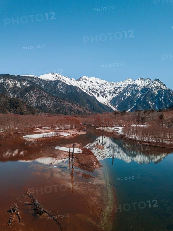 Snow-covered Japanese Alps reflected in Lake Taisho Pond